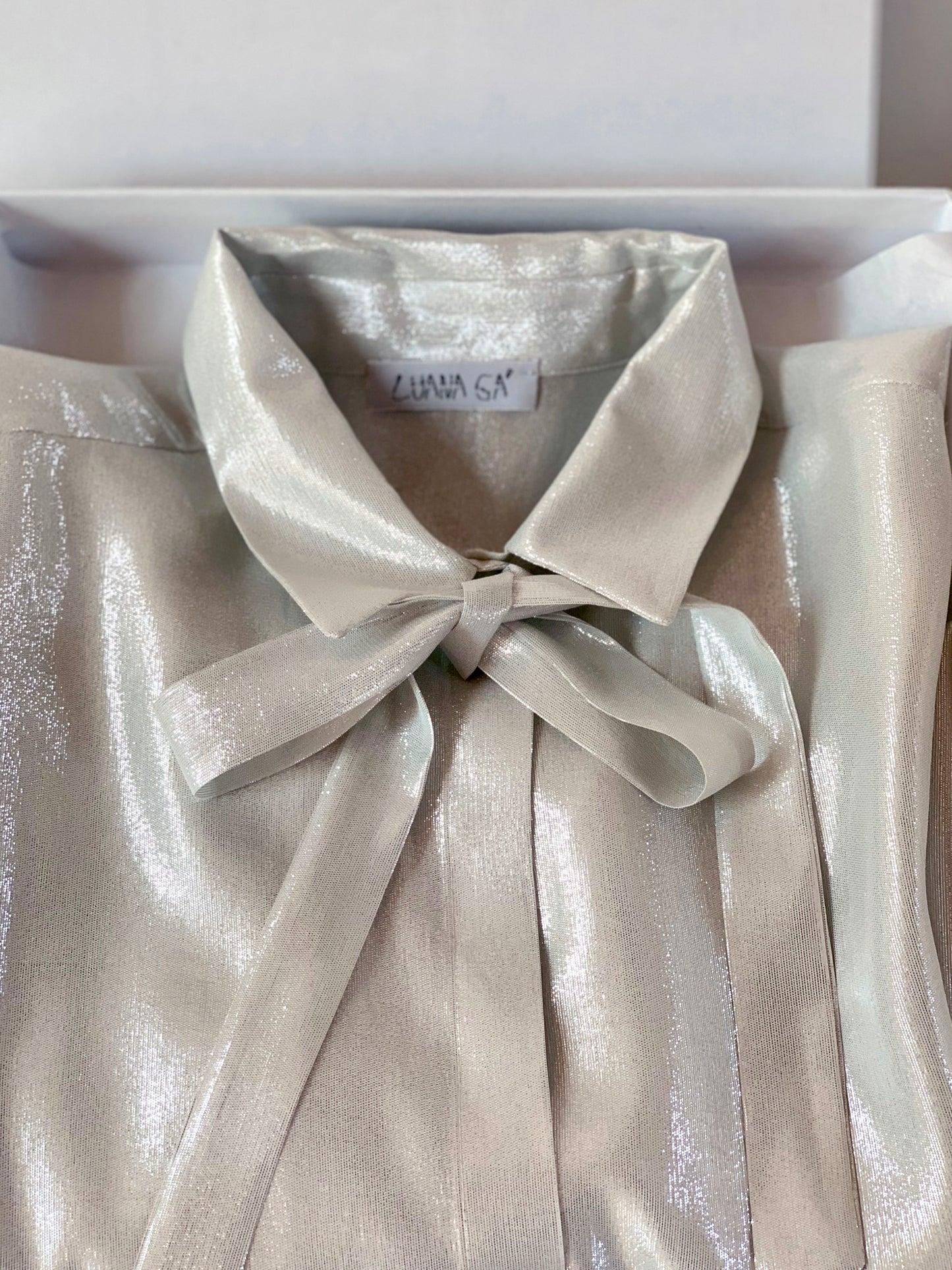 Luana Ga'  silver lurex shirt with a bow that can be used also as a belt.