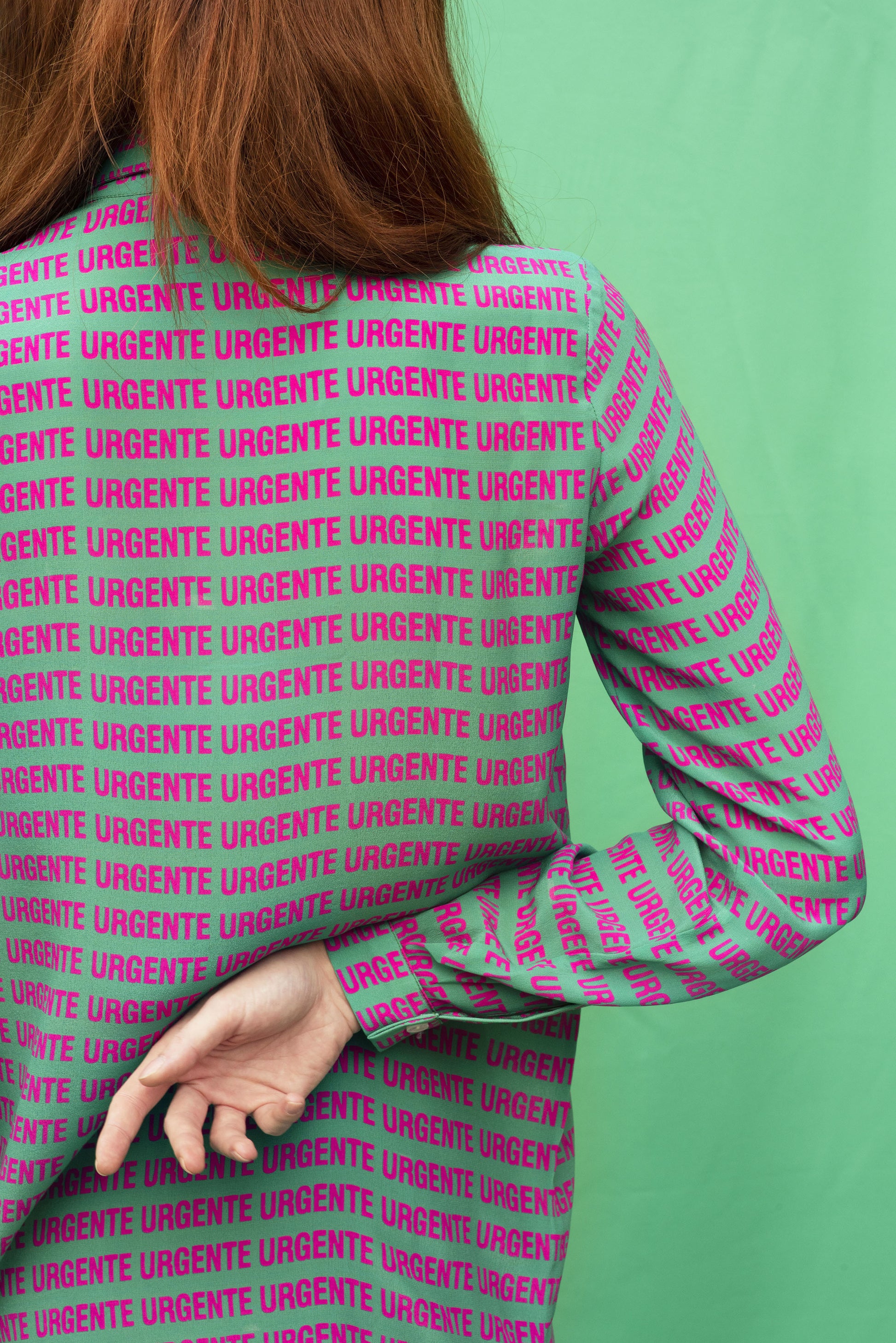 Luana Ga' Urgente silk shirt.It has a green background colour with a shocking pink Urgente type.