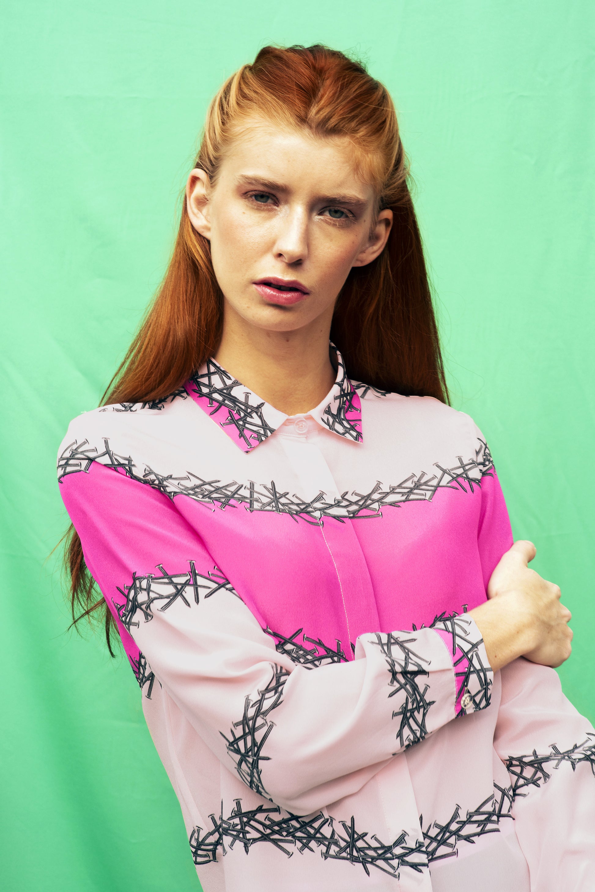 Luana Ga' silk shirt.The print is about lines of nails with a colour block in shocking pink