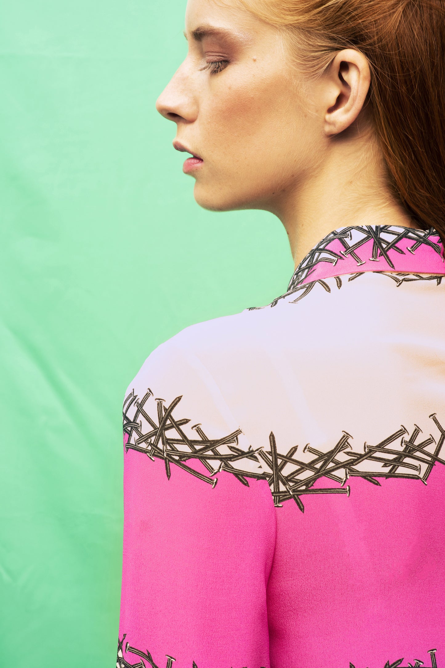 Detail of Luana Ga' printed shirt in lines of nails with a shocking pink colour block 